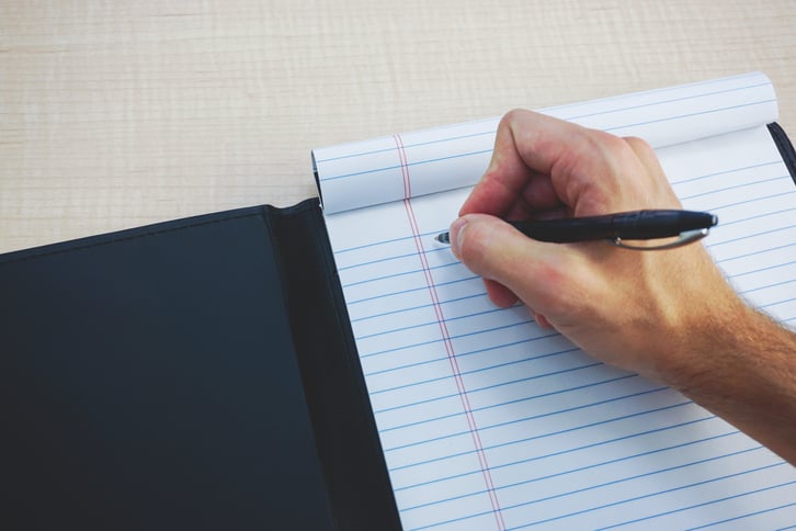 writing notes in leather folder