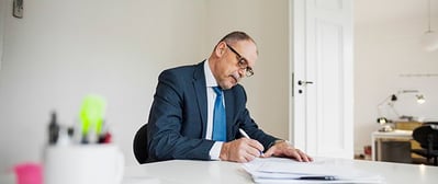 business-man-writing-letter-salutation-at-desk