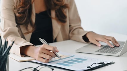 businesswoman-typing-draft-policies-operations-manual-computer