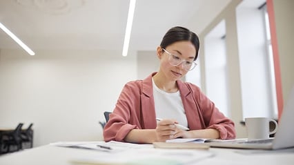 businesswoman-writing-technical-document-at-her-desk
