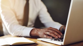 close-up-hands-writing-at-laptop-business-communication-skills