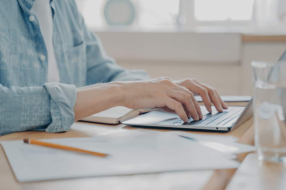 hands typing on laptop writing